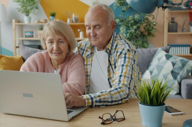 Elderly couple looking at a laptop together
