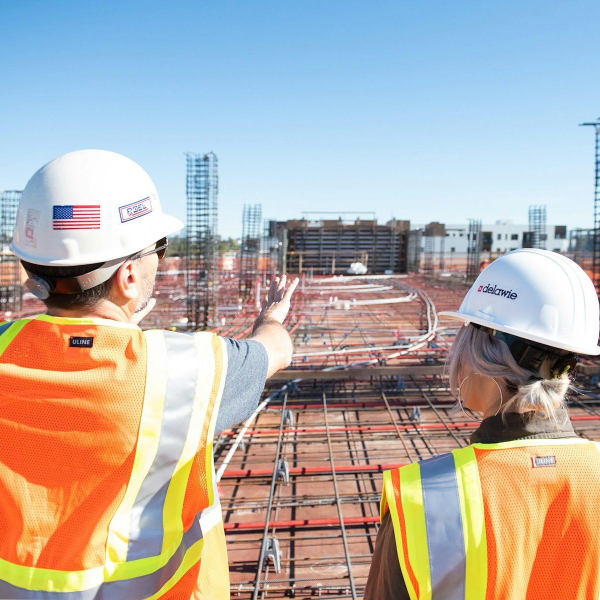 Unsplash Photo by Joe Holland two construction workers in safety vests at site