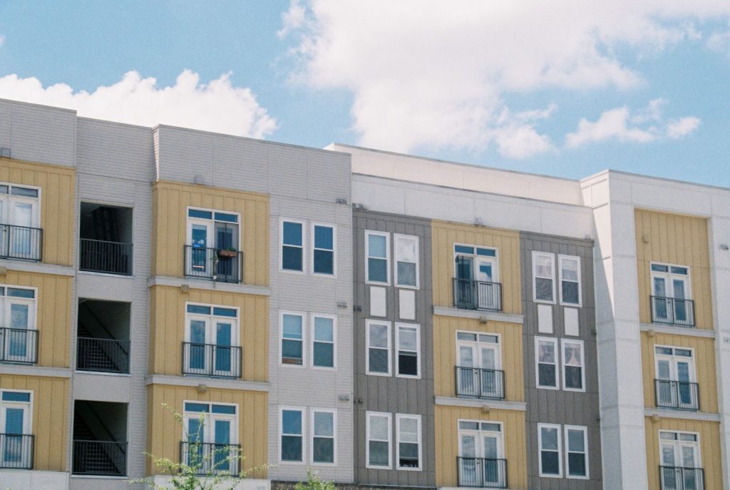 Pexels Photo by Mia Vargas Contemporary apartment building exterior with yellow and grey panels under a clear blue sky.