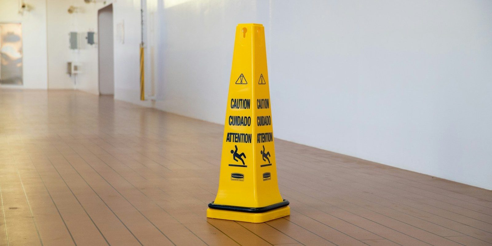 a yellow caution cone sitting on top of a hard wood floor