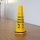 a yellow caution cone sitting on top of a hard wood floor