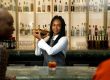 a woman standing at a bar pouring a drink