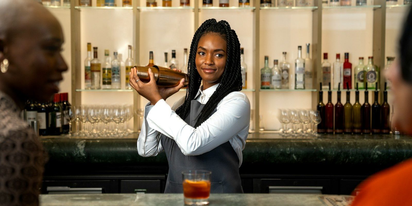 a woman standing at a bar pouring a drink