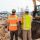 men in safety vests standing in front of a construction vehicle