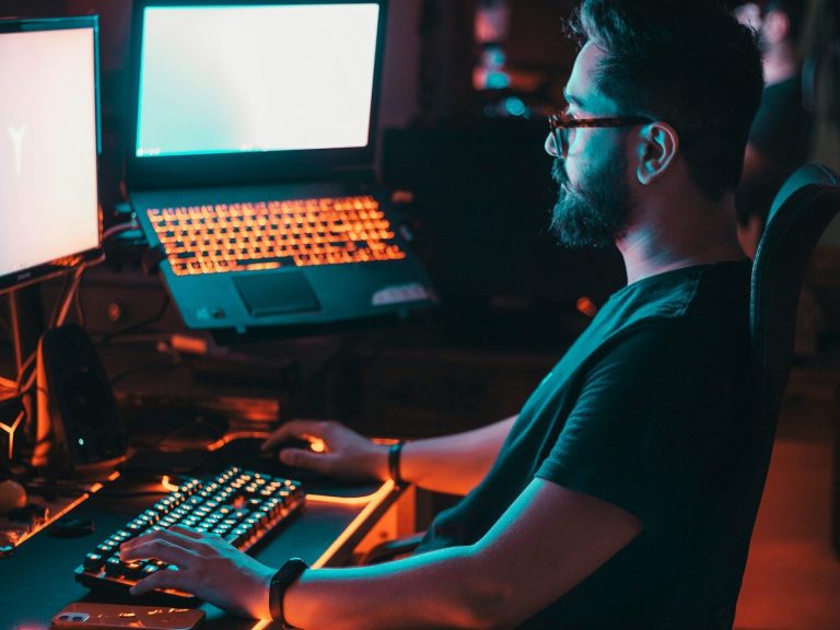 man in blue shirt using computer