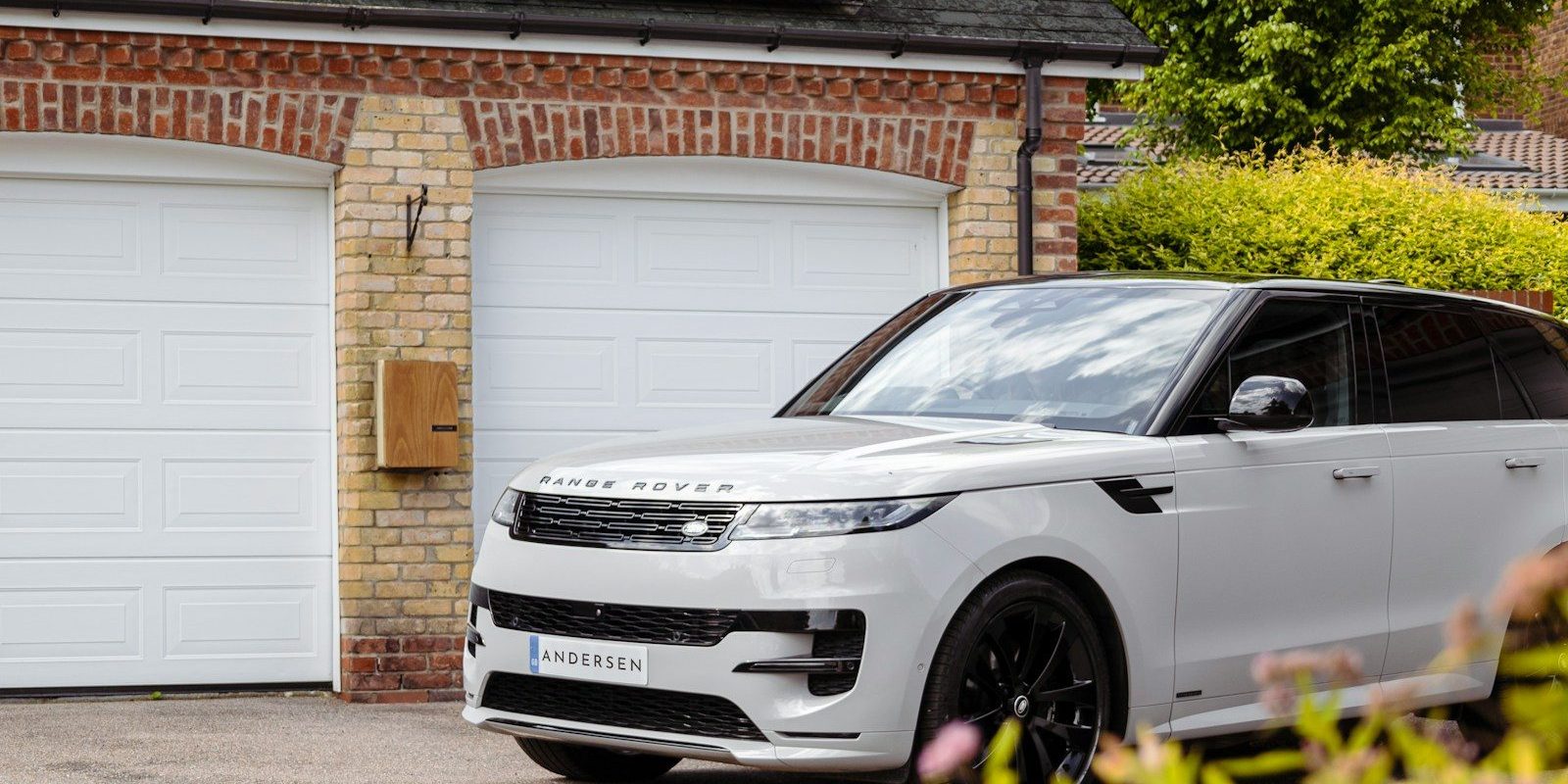 A white range rover parked in front of a house
