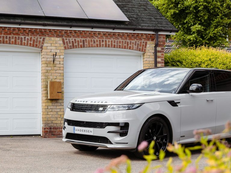 A white range rover parked in front of a house