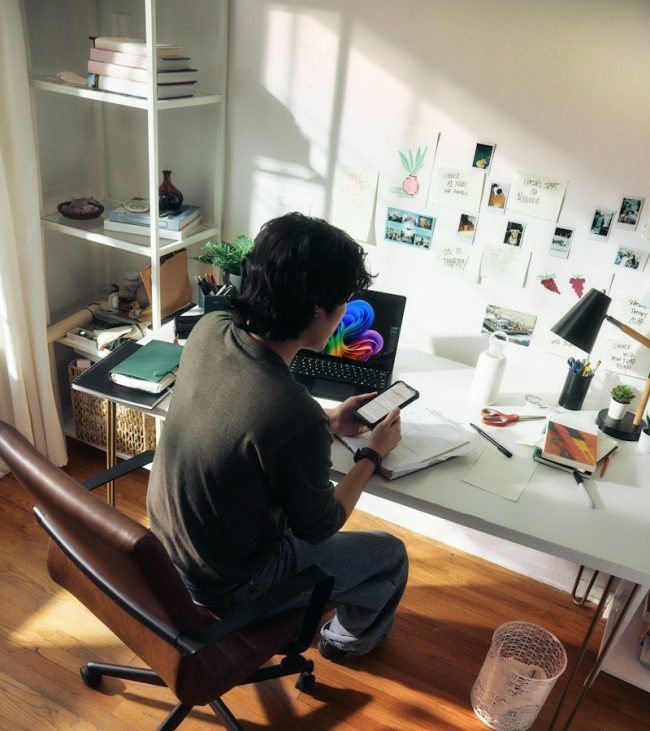 Man working at desk with laptop and phone