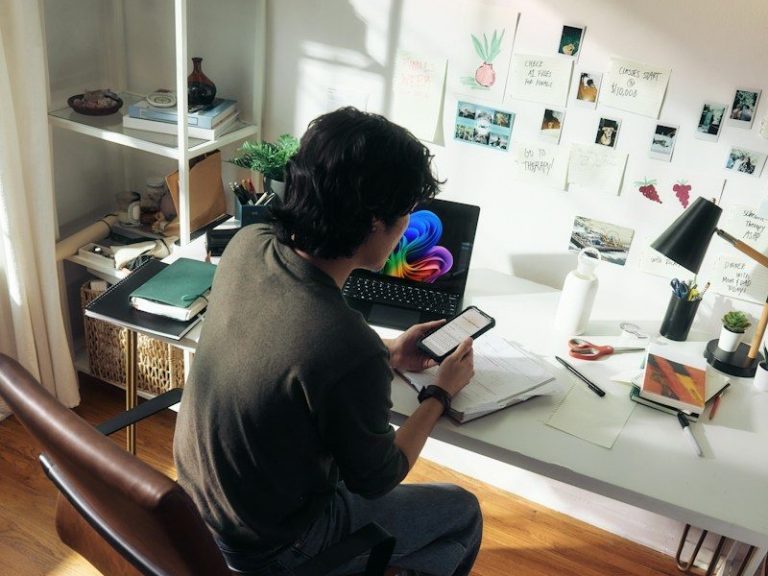 Man working at desk with laptop and phone