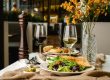 a table topped with plates of food and glasses of wine