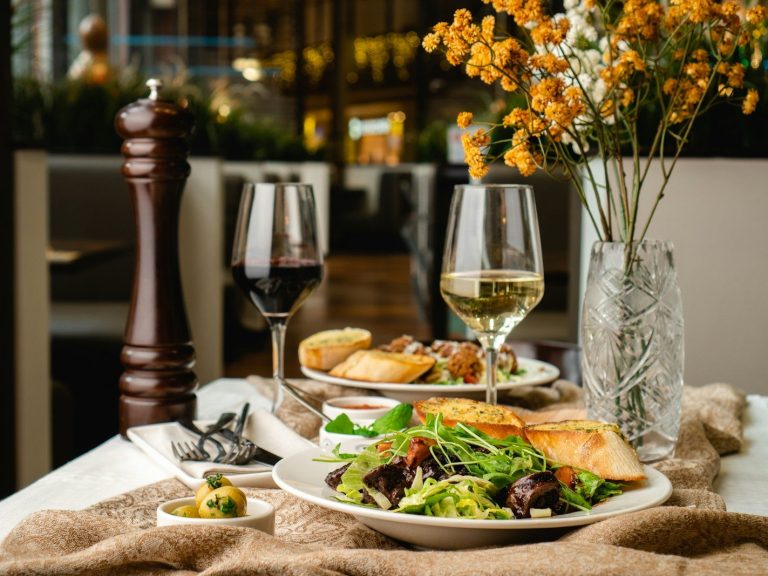 a table topped with plates of food and glasses of wine