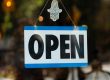 a sign that says open hanging from a window
