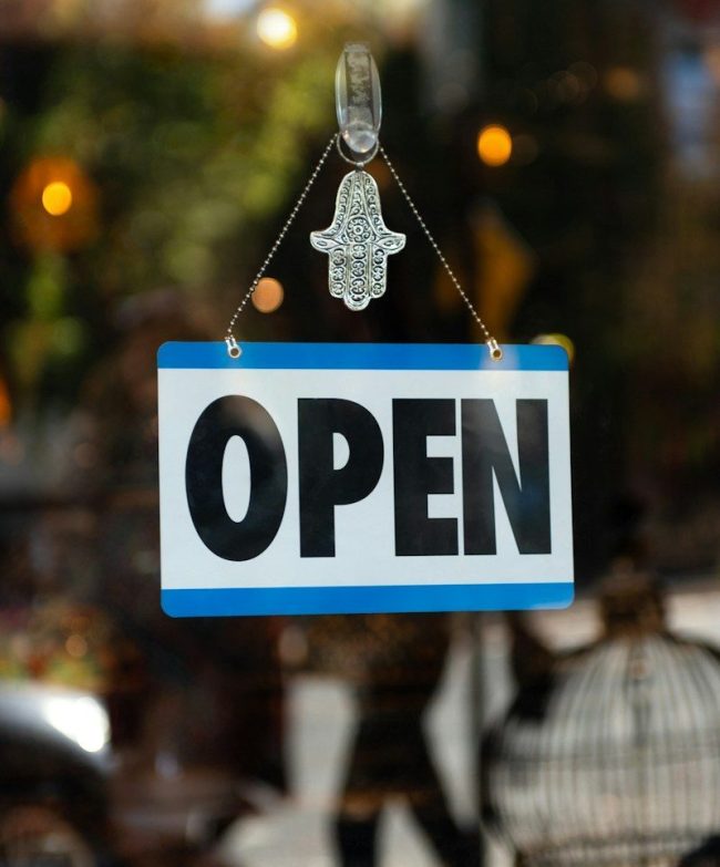 a sign that says open hanging from a window