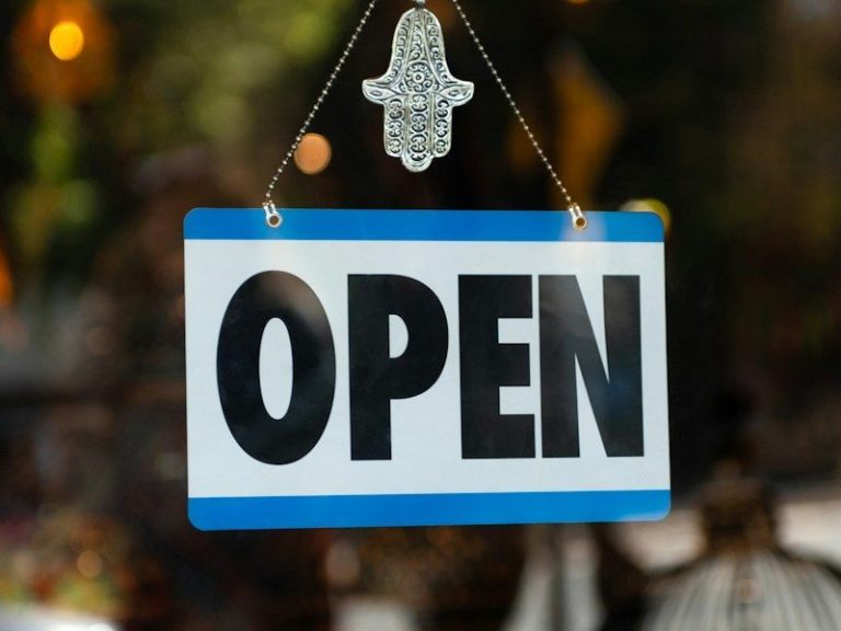 a sign that says open hanging from a window