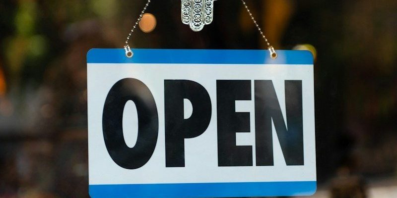 a sign that says open hanging from a window