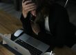 stressed woman with head in hands at laptop
